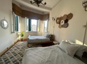 a bedroom with two beds and a window at Agora House for men only 仅限男性 in Alexandria