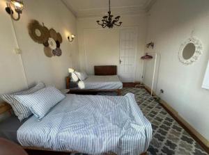 a bedroom with two beds and a chandelier at Agora House for men only 仅限男性 in Alexandria