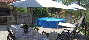 a table with an umbrella next to a pool at Cjase di Doro in Illegio