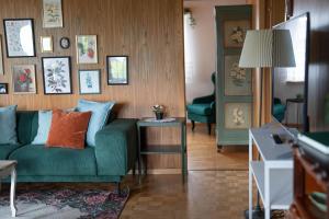 ein Wohnzimmer mit einer grünen Couch und einem Tisch in der Unterkunft Chalet Gritli I See I wandern I Luzern I Ski in Beckenried