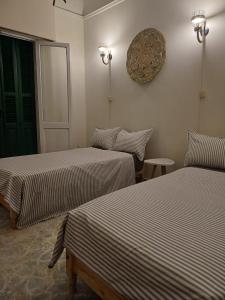 a bedroom with two beds and a clock on the wall at Agora House for men only 仅限男性 in Alexandria