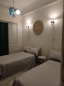 a bedroom with two beds and a clock on the wall at Agora House for men only 仅限男性 in Alexandria
