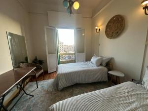 a small room with two beds and a window at Agora House for men only 仅限男性 in Alexandria