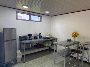 a kitchen with a refrigerator and a table with chairs at Playa Negra Zen Bistro in Puerto Limón