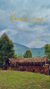 a hut with a grass roof in a field at Kanav Living - Wooden Cottage in Kanthalloor