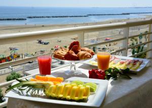 a table with two plates of food and a view of the beach at AmbientHotels Panoramic in Rimini