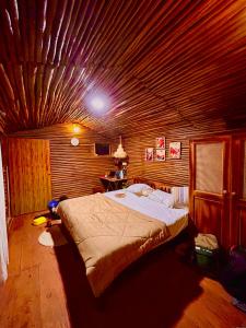 a bedroom with a bed with a wooden ceiling at Kanav Living - Wooden Cottage in Kanthalloor