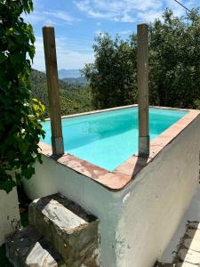 a swimming pool with two wooden poles on top of it at La Tahona (Cortijo Andaluz en las montañas) in Almogía +51 photos