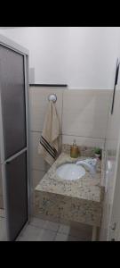 a bathroom with a sink and a towel on a counter at Casa da Lu in Aparecida