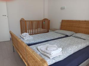 two twin beds in a room with towels on them at Appartamento FIORE in Cannero Riviera