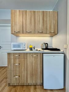 a kitchen with wooden cabinets and a white refrigerator at Gilė in Juodkrantė