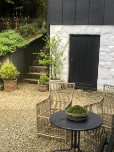 a patio with two chairs and a table and a door at Willa Urocze in Muszyna +59 photos