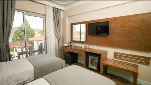 a hotel room with a bed and a fireplace and a television at Venezia Alaçatı in Yumru