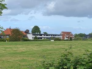 a field of grass with a building in the background at Küstenläufer in Schönhagen