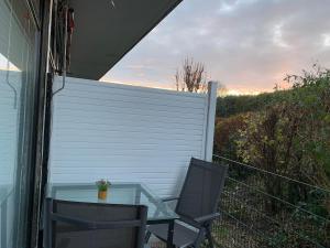 a glass table and two chairs on a patio at Küstenläufer in Schönhagen +6 photos