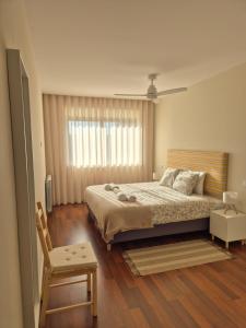 een slaapkamer met een groot bed en een stoel bij Sleep Swell in Porto