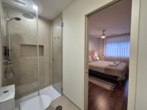 een badkamer met een inloopdouche en een bed bij Sleep Swell in Porto