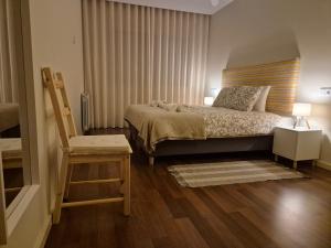 een slaapkamer met een bed, een stoel en een tafel bij Sleep Swell in Porto