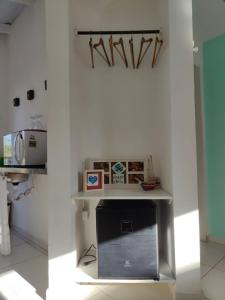 Dos imágenes de una habitación blanca con un televisor. en Pousada Casa da Praia Juquehy - Duplo, en Juquei