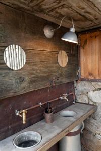 a bathroom with a sink and a light on the wall at Relais - U Machjonu in Tolla +27 photos