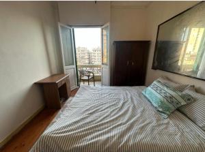 a bedroom with a large bed and a window at Agora House for men only 仅限男性 in Alexandria