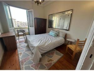 a bedroom with a bed and a chair and a window at Agora House for men only 仅限男性 in Alexandria