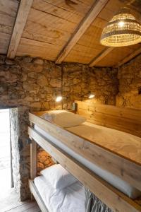 a bed in a room with a stone wall at Relais - U Machjonu in Tolla