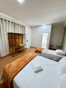 a bedroom with two beds with towels on them at Pousada Caminho da Passagem in Cabo Frio +86 photos