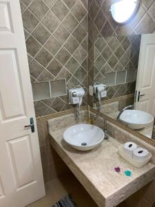 a bathroom with a sink and a mirror at Suite Canto da Montanha in Monte Verde