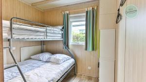 a bunk bed in a small room with a window at Chalet 68 Village de la Mer in Saint-Hilaire-de-Riez +11 photos