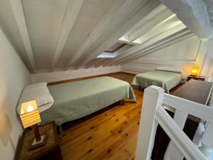 a small room with two beds and a wooden floor at Apartamento Picos de Europa in Trasvia