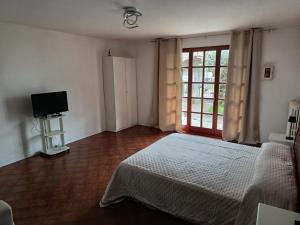 a bedroom with a bed and a tv and a window at Casa Eben-Haezer in Fiumana