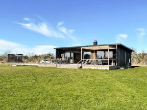 a black house with a green field in front of it at 5 star holiday home in Löttorp in Löttorp