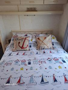 a bed with a bedspread with boats on it at Mackies Memories. in Hemsby +6 photos