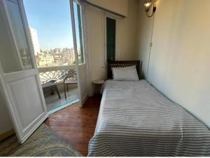 a small room with a bed and a window at Agora House for men only 仅限男性 in Alexandria