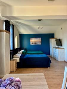a bedroom with a bed and a blue wall at Rezydencja Sara in Międzyzdroje