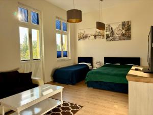 a bedroom with a bed and a couch and a table at Rezydencja Sara in Międzyzdroje