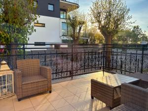 a balcony with two chairs and a table and a fence at Rezydencja Sara in Międzyzdroje