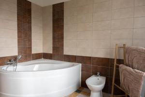 a bathroom with a white tub and a toilet at Villa Léa Alès 5 chambres in Alès