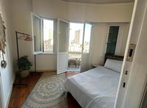 a bedroom with a bed and two windows at Agora House for men only 仅限男性 in Alexandria