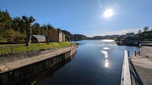 a river with the sun reflecting on the water at Newly built, bright apartment in Skien