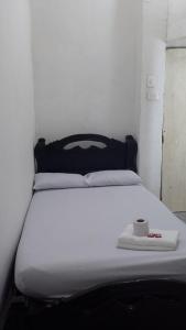 Hostal #10-33 في كارتاهينا دي اندياس: سرير ابيض عليه كوب