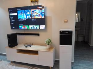 a desk with a tv on a wall at Staycation by Winnie-Weber Generations -2 bedrooms in Nairobi +1 photo