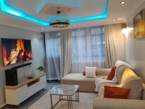 a living room with a couch and a tv at Staycation by Winnie-Weber Generations -2 bedrooms in Nairobi