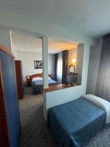 a hotel room with two beds and a mirror at Hotel La Terrazza in Porto San Giorgio