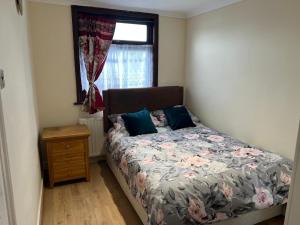 een bed in een kamer met een raam en een bed sidx sidx sidx bij SAI Residence in Ilford