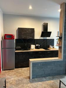 una cucina con un frigorifero in acciaio inossidabile in una stanza di La Ville - Rouge a Zator
