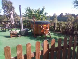 a playground in a backyard with a wooden fence at Podere Kiri Dome Experience in Decimomannu