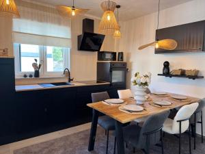 a kitchen with a wooden table and chairs in a kitchen at Apartman Magic View in Baška Voda