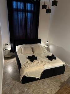 una camera da letto con un letto con testiera e cuscini neri di La Ville - Rouge a Zator